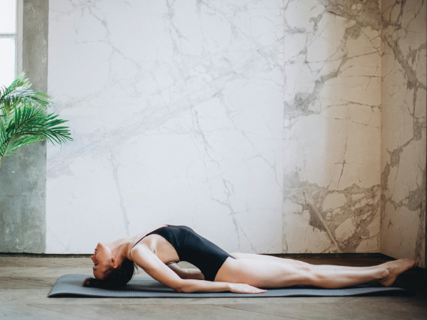 A woman demonstrating the fish pose in yoga.